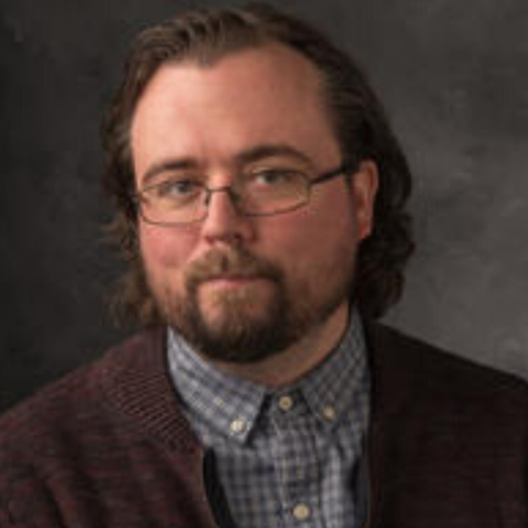 Portrait of Mike Meginnis against a gray background